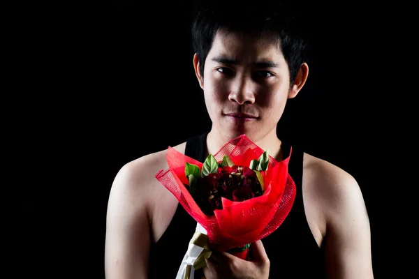 アジアの少年暗い背景の赤い花束 — ストック写真