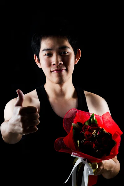 Asian boy with red bouquet in dark background — Stock Photo, Image