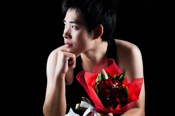 Asiático chico con rojo ramo en oscuro fondo —  Fotos de Stock