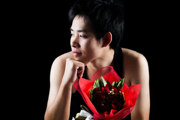 Asian boy with red bouquet in dark background — Stock Photo, Image