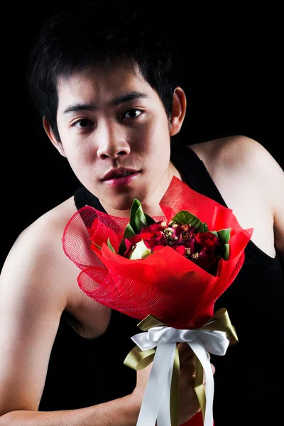Asian boy with red bouquet in dark background — Stock Photo, Image