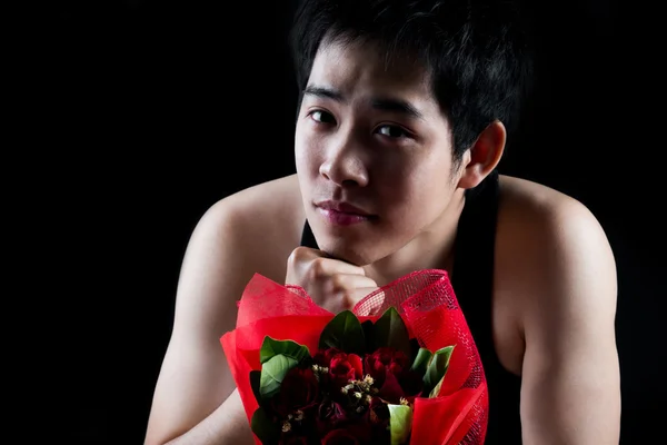 Asian boy with red bouquet in dark background — Stock Photo, Image