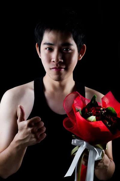 Asiatico ragazzo con rosso bouquet in scuro sfondo — Foto Stock