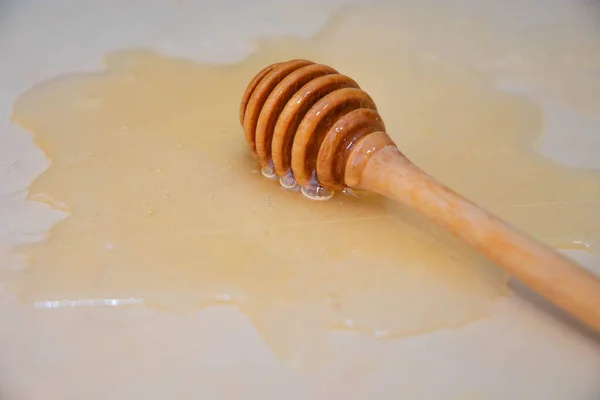 Die Löffelspindel Liegt Honig Auf Einer Weißen Holzplanke — Stockfoto