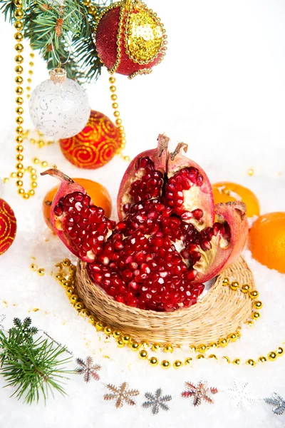 Frischer Granatapfel. Weihnachtsschmuck für den Weihnachtsbaum auf einem Holztisch. — Stockfoto