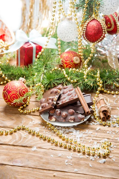 Chocolate with nuts and cinnamon on the holiday table. christmas decoration — Stock Photo, Image