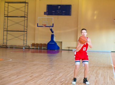 elleri ve kırmızı üniforma bir top ile basketbolcu. spor salonunda egzersiz basketbolcu