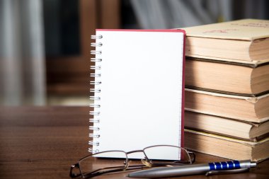 defter, kitap, gözlük ve kalem yığını