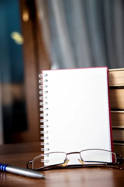 Notebook, a stack of books, glasses and pen — Stock Photo, Image