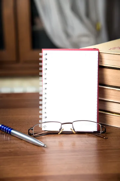 Quaderno, una pila di libri, bicchieri e penna — Foto Stock