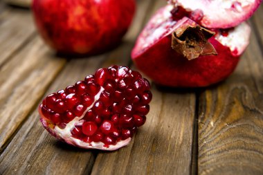 Ripe juicy pomegranate on wooden table clipart