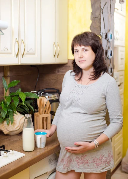 Schöne schwangere Frau mit einer Tasse Milch — Stockfoto