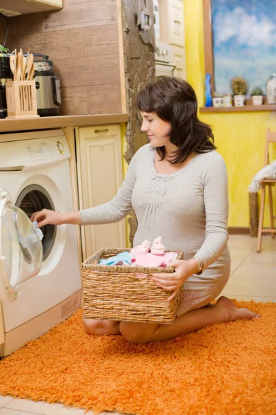 Pregnant woman with baby clothes — Stock Photo, Image
