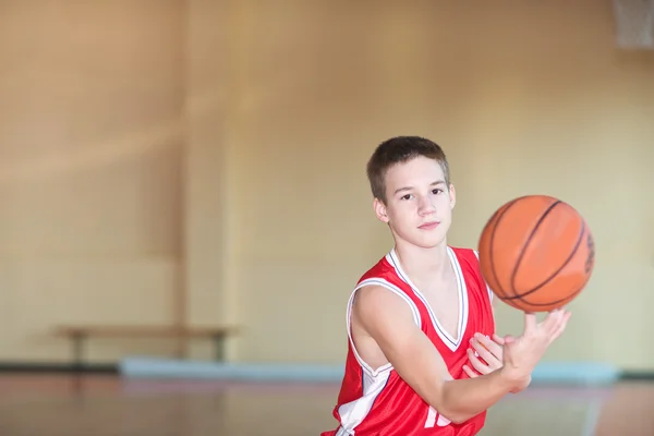 Basketball player with a ball in his hands and a red uniform. — Stock Photo, Image