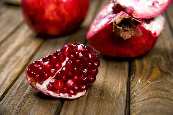 Rijpe sappige granaatappel op houten tafel — Stockfoto