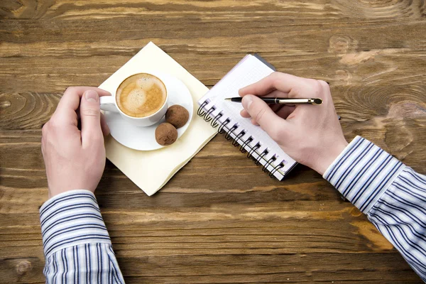 Man drinking coffee with chocolates — Stock Photo, Image