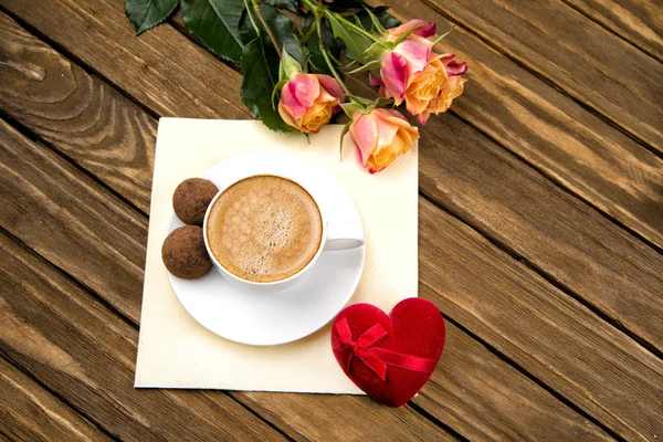 Cup of coffee on a wooden table, chocolate truffle — Stock Photo, Image