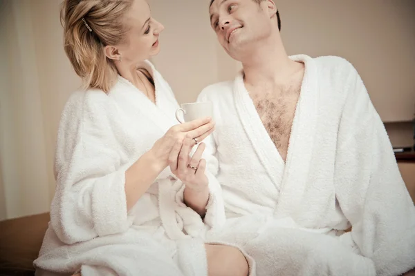 Pareja joven trabajando en casa en la cama — Foto de Stock