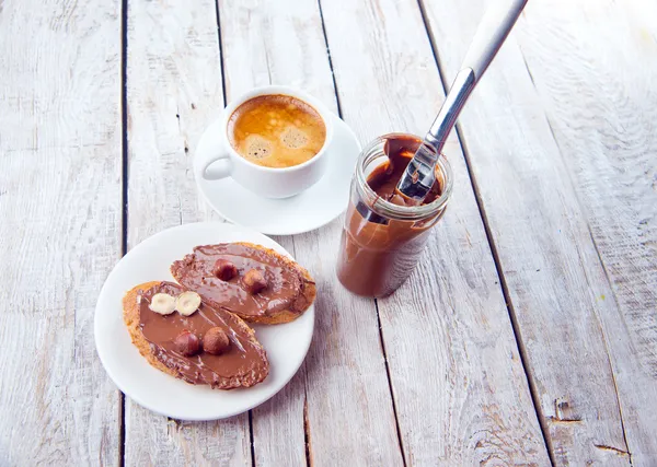 Pão com creme de chocolate e uma xícara de café — Fotografia de Stock
