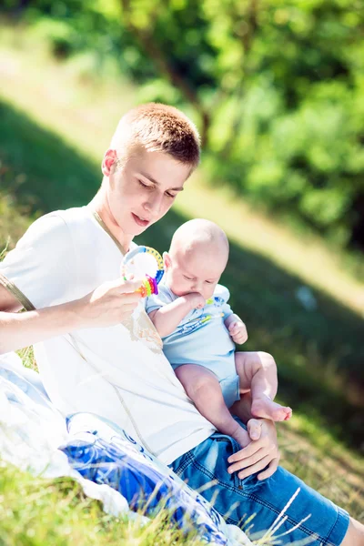 Padre joven con bebé en la naturaleza . — Foto de Stock