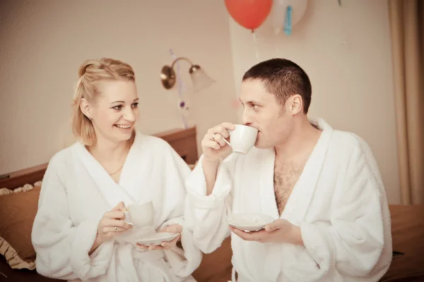 Мужчина и женщина пьют кофе утром в постели . — стоковое фото