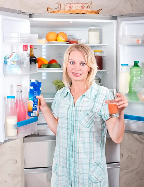 Junge Mutter mit Kind holt Lebensmittel aus dem Kühlschrank. — Stockfoto