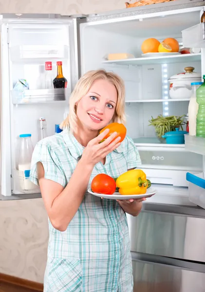 Junge Mutter mit Kind holt Lebensmittel aus dem Kühlschrank. — Stockfoto