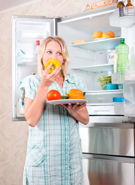 Junges schönes Mädchen nimmt Lebensmittel aus dem Kühlschrank. — Stockfoto