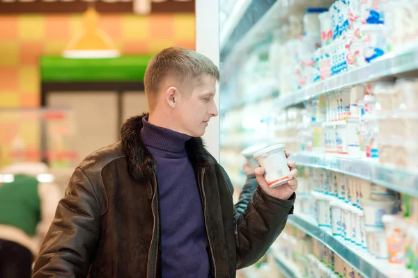 El hombre compra productos lácteos en el supermercado — Foto de Stock