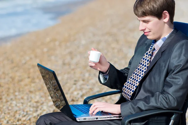 Un uomo che lavora su un computer all'aperto . — Foto Stock