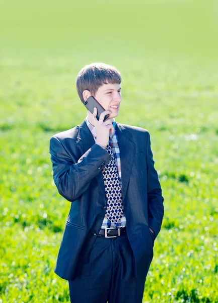Χαρούμενος νεαρός μιλάει για ένα κινητό τηλέφωνο σε εξωτερικούς χώρους — Φωτογραφία Αρχείου