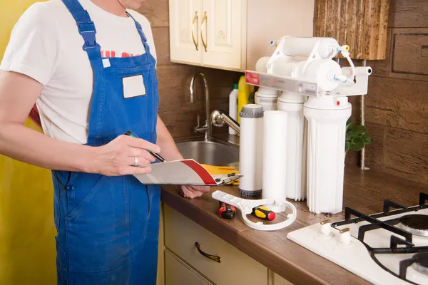 Loodgieter ververs het water filter — Stockfoto