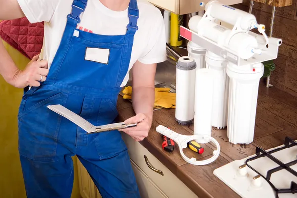 Loodgieter ververs het water filter — Stockfoto