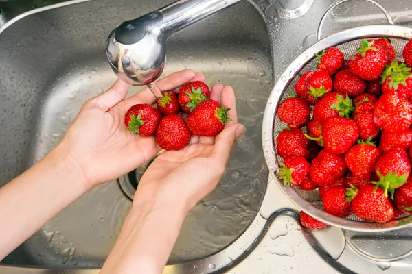 Girl washes strawberries — Stock Photo, Image