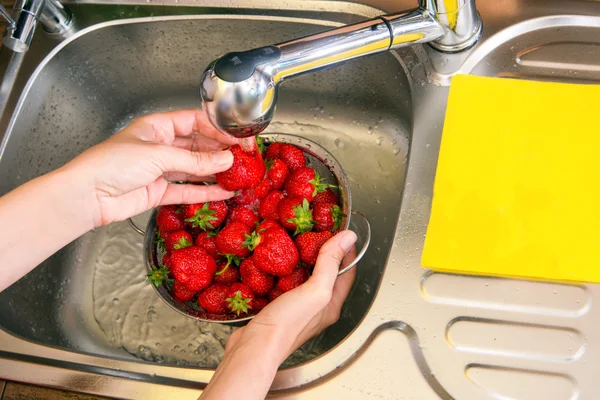 Mädchen wäscht Erdbeeren — Stockfoto
