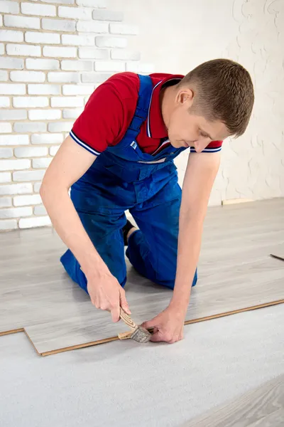 Young handsome men laid laminate floor covering, perform repairs — Stock Photo, Image