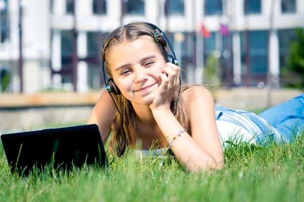 Junges schönes junges Mädchen hört Musik mit Kopfhörern im Freien — Stockfoto