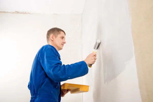 Pintura trabalho, construtor homem pinta a parede — Fotografia de Stock