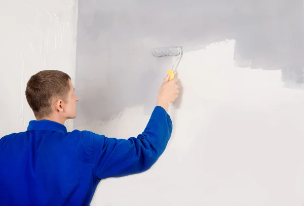 Painting work, builder man paints the wall — Stock Photo, Image