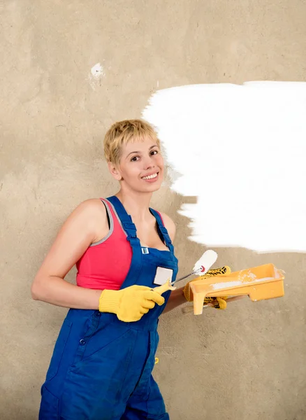Unga vackra kvinnan målar väggen, byggnationen — Stockfoto