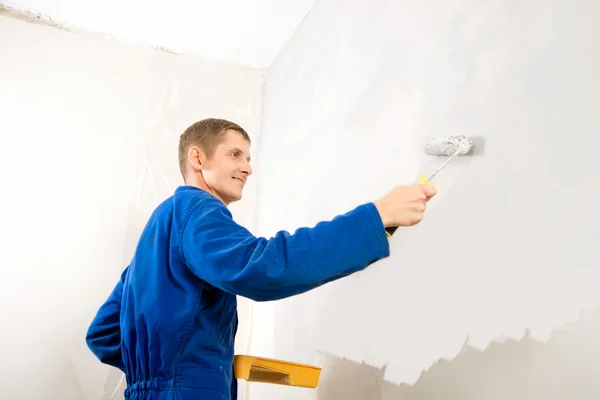 Trabajos de pintura, hombre constructor pinta la pared —  Fotos de Stock