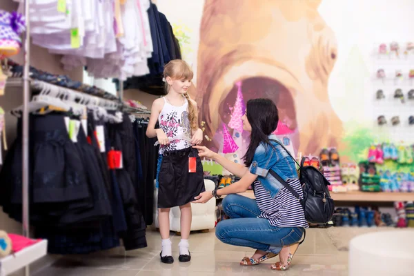 Cute beautiful little girl with her mother to buy clothes in sho — Stock Photo, Image