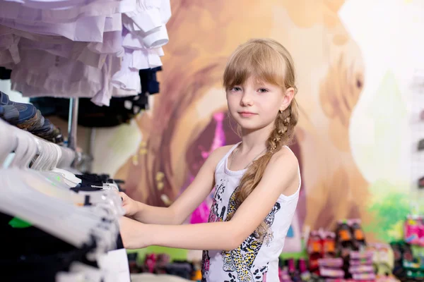 Bastante hermosa chica elige ropa en la tienda — Foto de Stock