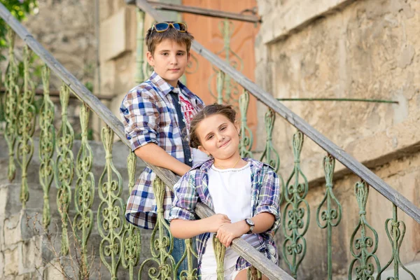 Hermano y hermana al aire libre en la ciudad, chico con monopatín —  Fotos de Stock