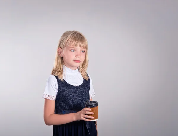 Schoolmeisje meisje het drinken van thee in een beker papier — Stockfoto