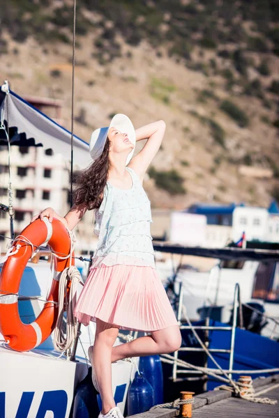 Joven hermosa chica caminando a lo largo del club náutico frente al mar —  Fotos de Stock