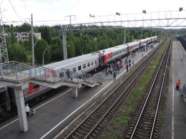 Svir, Rusya, 6 Ağustos 2021. Tren istasyonunun üst manzarası. İnsanlar trenden iniyor. Oktyabrskaya demiryolunun bölge tren istasyonu. İki tür elektrik çekme için kenetlenme istasyonu