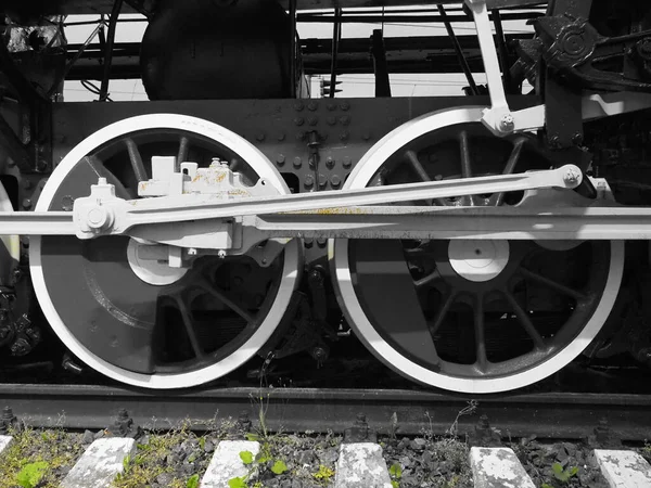 レトロな列車2輪。ベッドやレール、メカニズム、ピストンやガイド。蒸気機関車で19世紀初頭20世紀の機関車。緑の草と黒と白の車輪。ヴィンテージスタイル — ストック写真