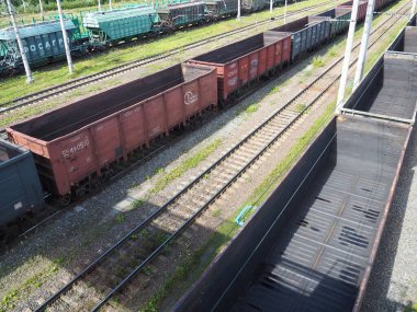 Svir, Rusya 6 Ağustos 2021. Yukarıdan yük trenleri ve vagonlar geliyor. Bir yaz gününde demiryolu. Ulaşım, kargo, lojistik ve iş süreci. Boş metal vagonlar. Uluslararası kargo taşımacılığı