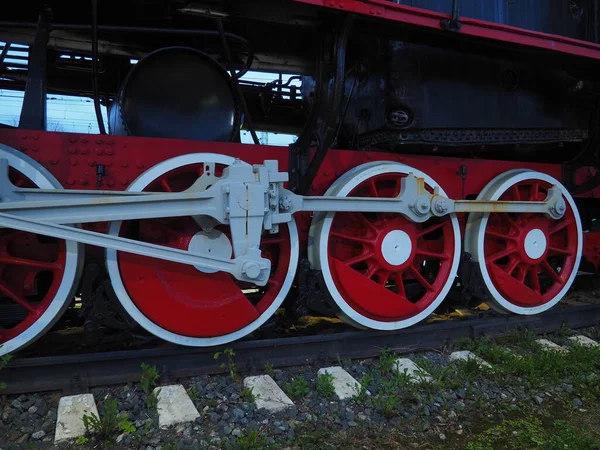 Egy mozdony vagy vonat retro vintage kerekei közelednek. Piros nagy nehézfém kerekek dugattyús vezetőmechanizmussal. 19-20. századi mozdony gőzmozdonnyal. — Stock Fotó